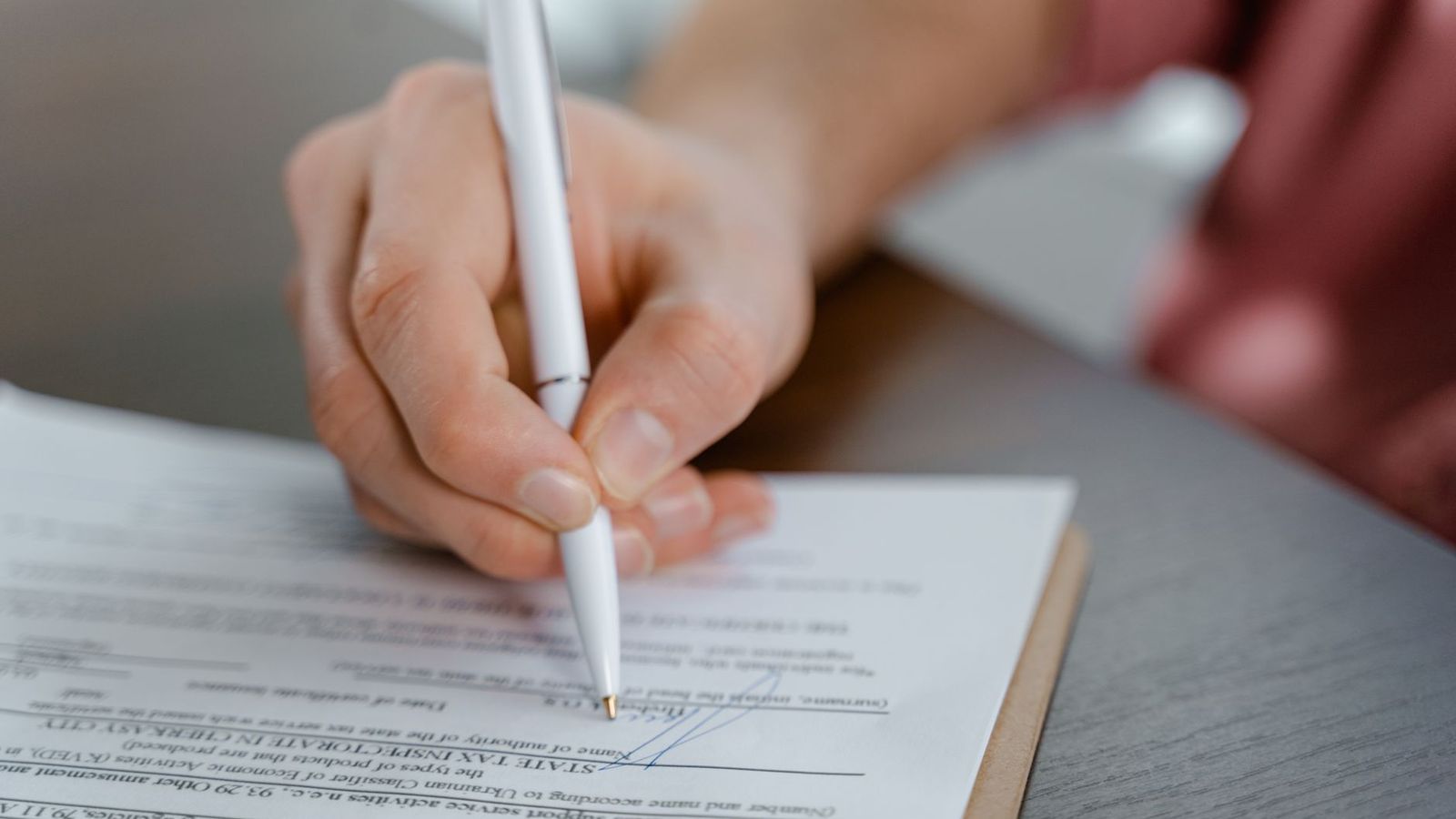 Une signature de contrat, stylo et documents sur la table