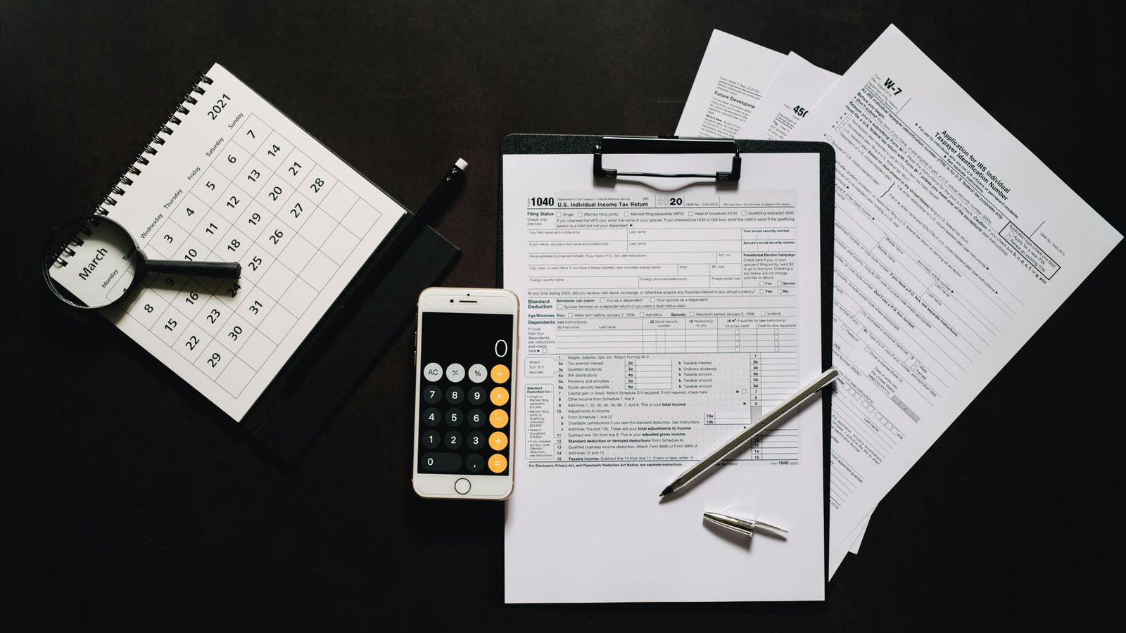 Un formulaire fiscal, une calculatrice et des documents sur un bureau