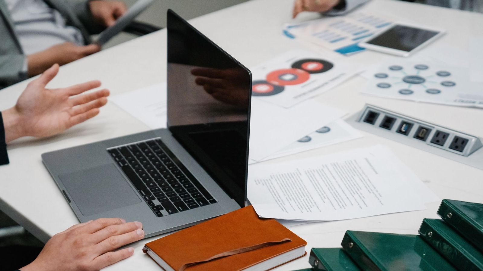 Une réunion de travail autour de dossiers et d'un ordinateur